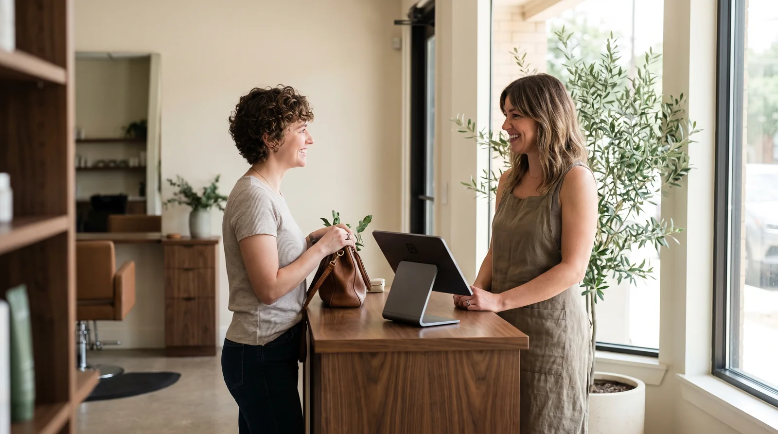 A salon owner welcoming a customer at the reception desk
